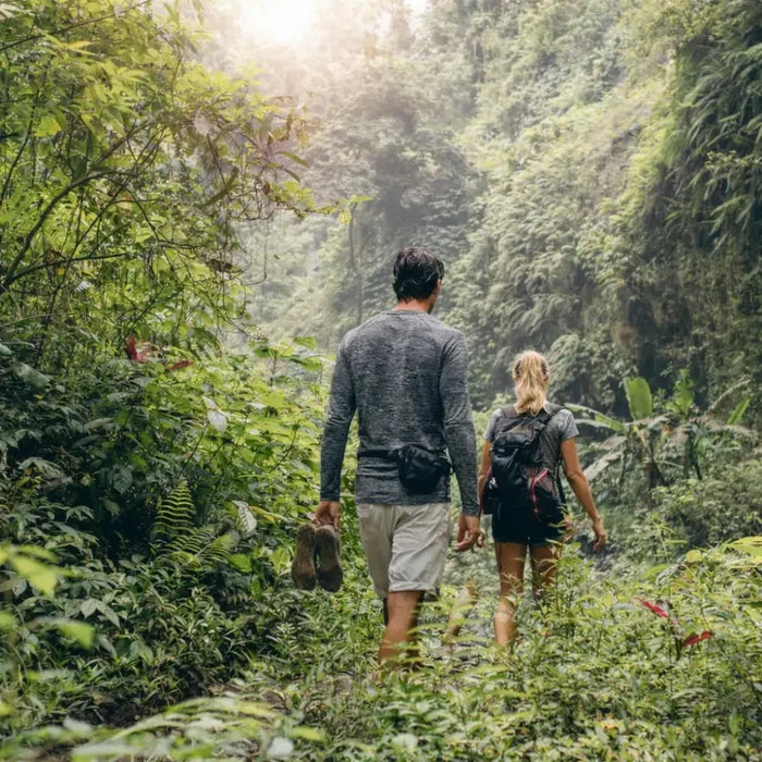 Man and a woman trekking through the jungle wearing Sub Zero anti-mosquito summer base layer tops