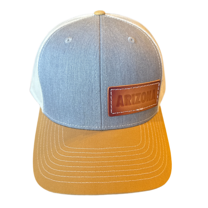Front view of Arizona Leather Trucker Hat with dark crown and tan brim against white background.