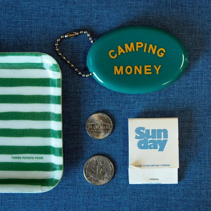 Teal camping money coin pouch on blue fabric with coins and a Sun day card nearby