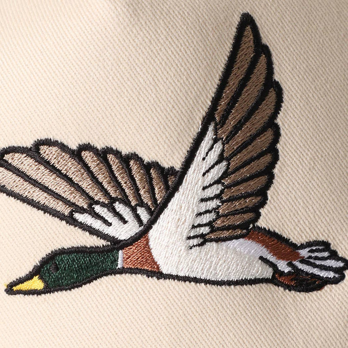 Close-up of flying mallard embroidery on beige hat fabric