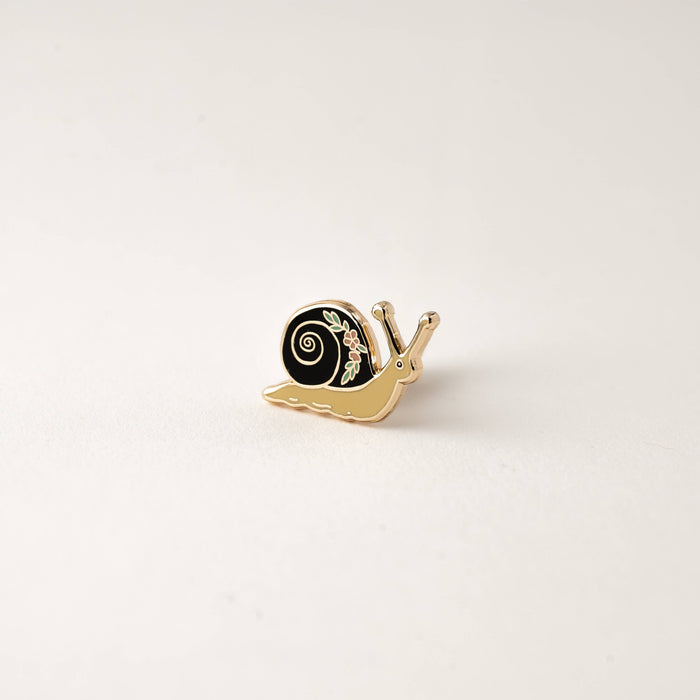 Garden Snail enamel pin with blue shell and yellow body on white background