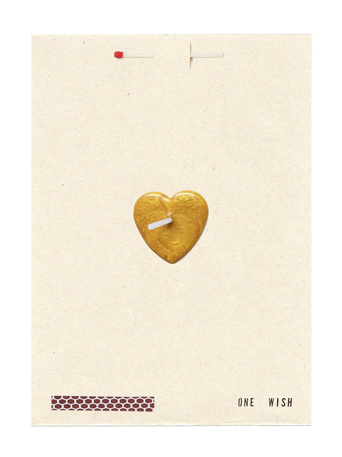 A card with a gold heart-shaped candle with a wick on a beige background, featuring the text 'ONE WISH'.
