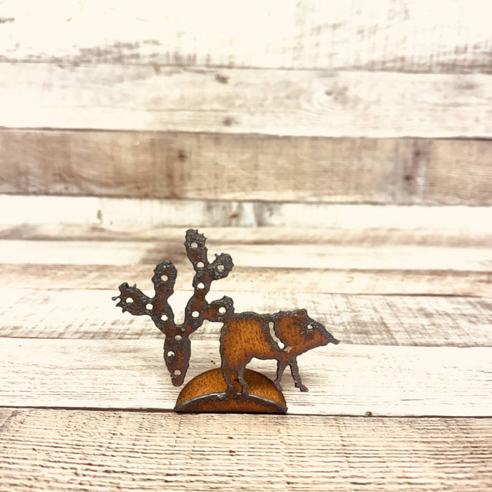 Rusty metal cutout of a javelina with prickly pear cactus on a circular base