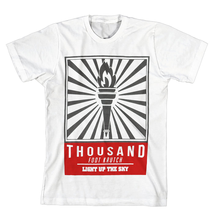 White T-shirt with a black flaming torch and radiating lines at the center. Below, a red text box displays THOUSAND FOOT KRUTCH and LIGHT UP THE SKY in white letters. Brand: Thousand Foot Krutch.
