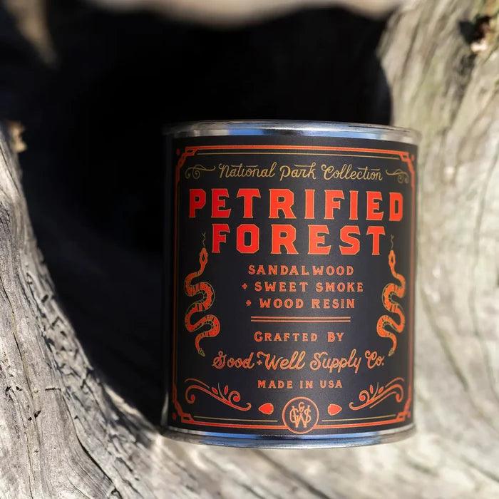 Close up of Petrified Forest candle label on a black background with ornate orange typography