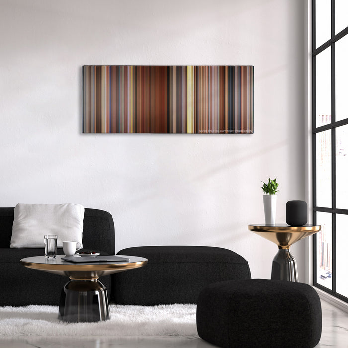 Sideways color palette canvas above a black sofa with a gold-topped table