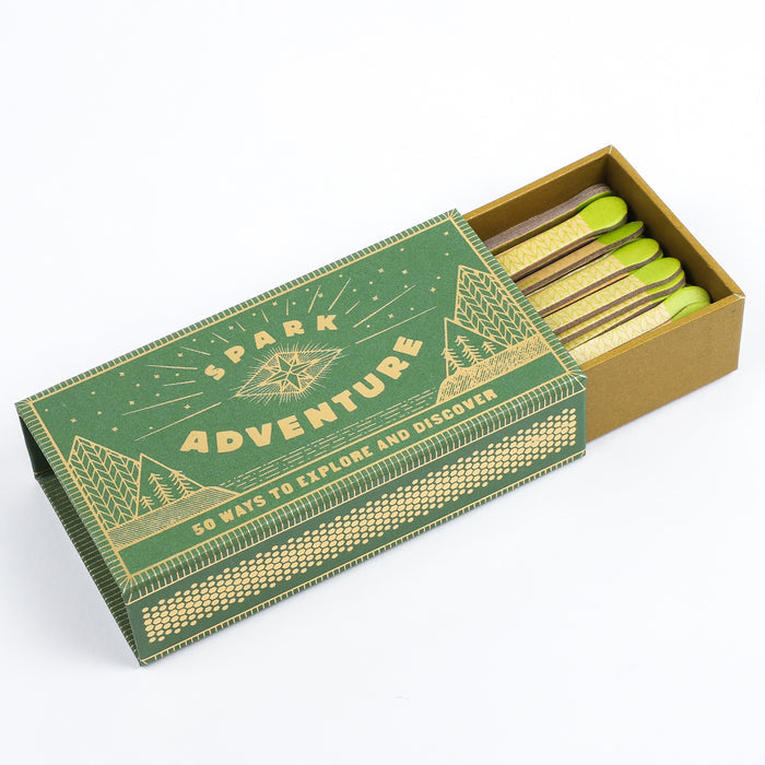 Open Spark Adventure faux matches box with lime tipped matches arranged in the inner tray and two loose sticks nearby