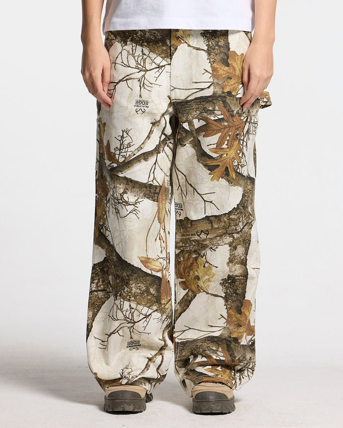 V1 CARPENTER PANTS REALTREE WHITE - white realtree camo carpenter pants, front view on female model - Cold Culture