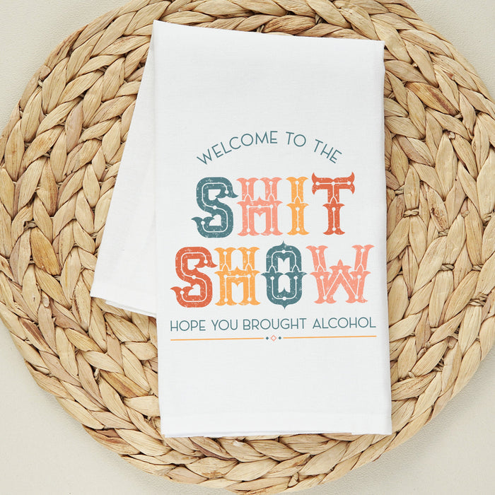 White tea towel printed with the colorful text Welcome to the Shit Show