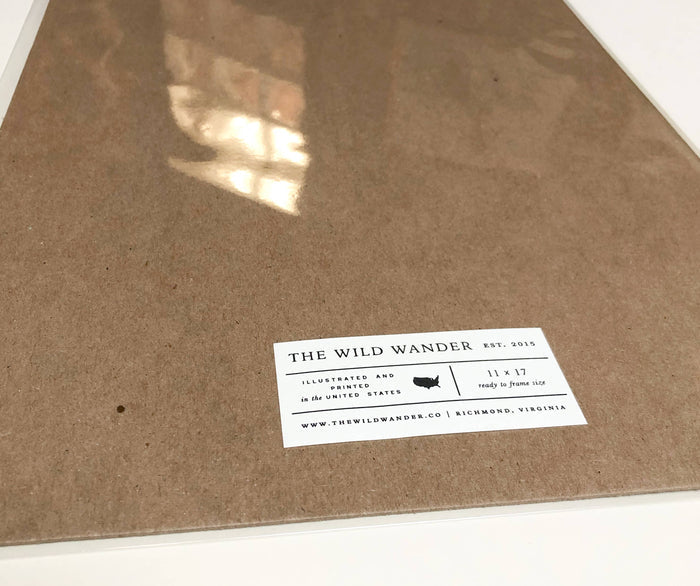 The Wild Wander label for Yellowstone National Park Field Guide 11 x 17 on a brown surface