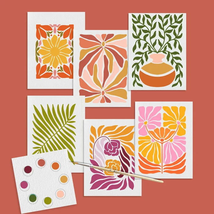 Five vibrant abstract watercolor flower prints arranged as cards on a warm terracotta background with a paint palette and brush.