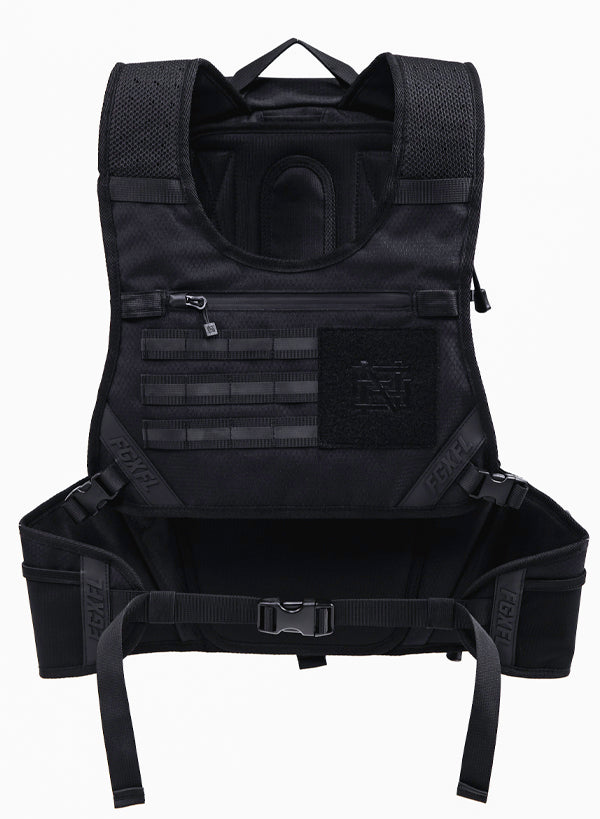 The front of our black Apex bag. Featuring a tactical chest rig. There is a zipper compartment with a water resistant zipper. Below there are tactical webbing for accessories (sold separately). To the right of the webbing is a black fabric area featuring our monogram Flag nor Fail logo. In this area separately sold patches can be attached via Velcro. The photo also shows that the waist can be secured with a buckle.