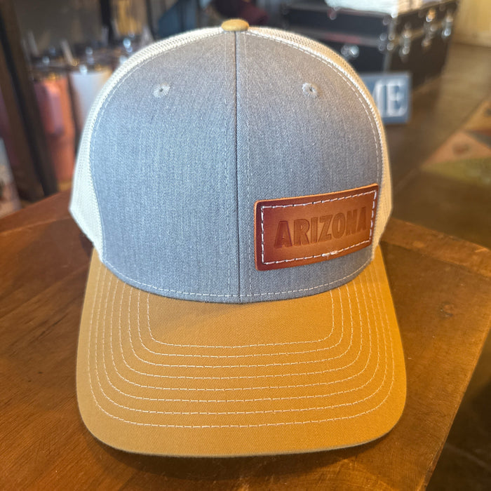 Front view of Arizona Leather Trucker Hat with denim crown, tan brim, and brown leather patch.