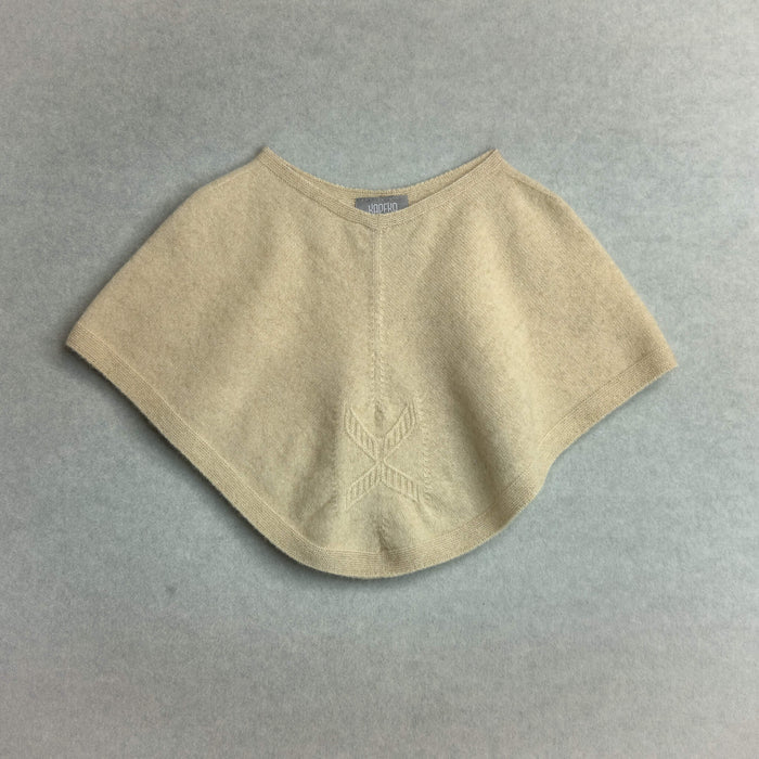 Beige knitted poncho on a gray background