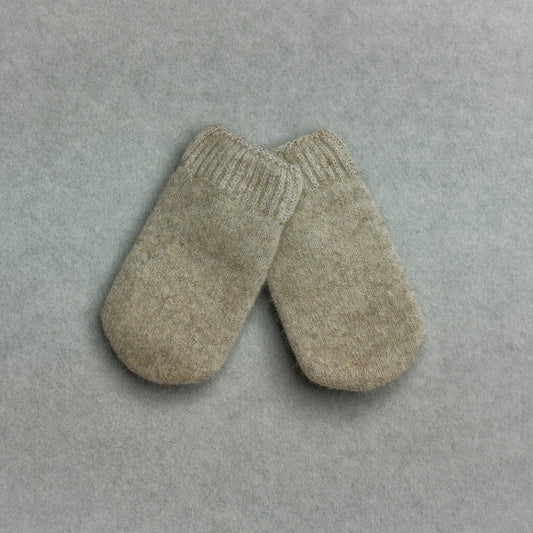 Pair of beige baby mittens on a gray background