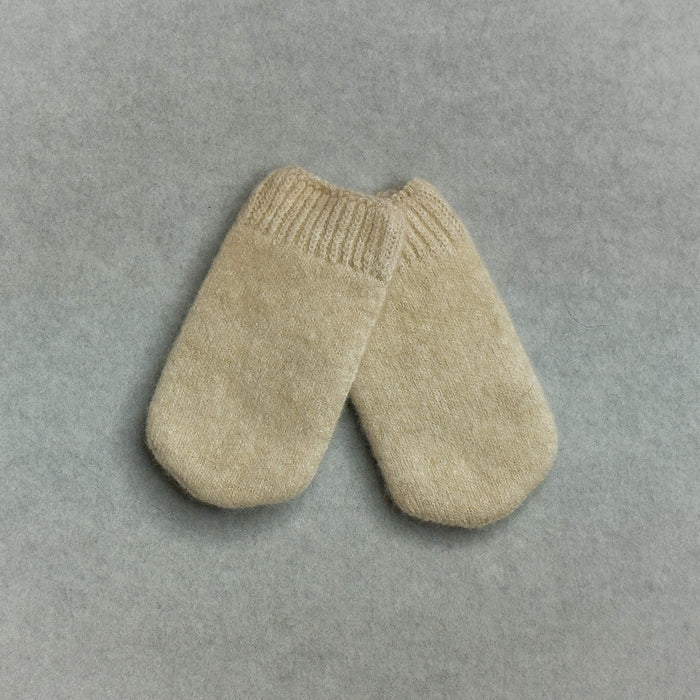 Pair of beige knitted baby mittens on a gray background