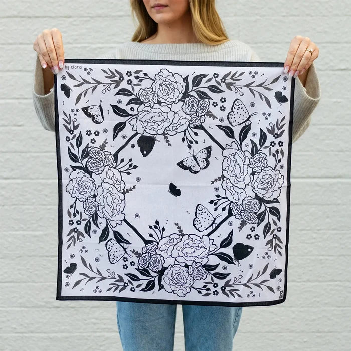 Model holding Black Butterfly and Flowers Bandana displaying the floral and butterfly print.