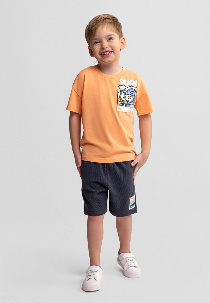 Boys' apricot t-shirt with graphic and gunmetal waffle shorts, front view.