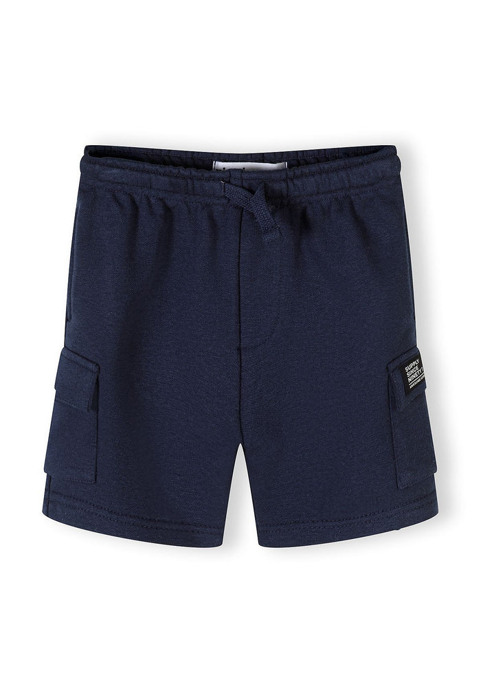 Detail of navy blue shorts with elasticated waistband and side pockets.