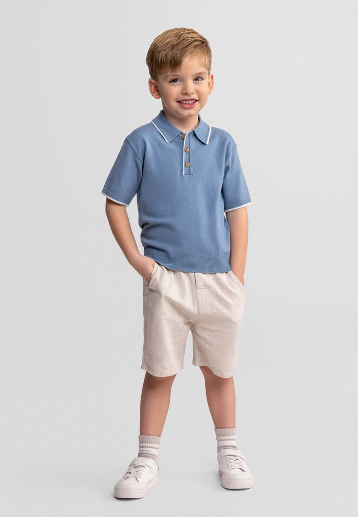 Boys light blue polo shirt with beige shorts, front view, featuring buttons and side pockets.