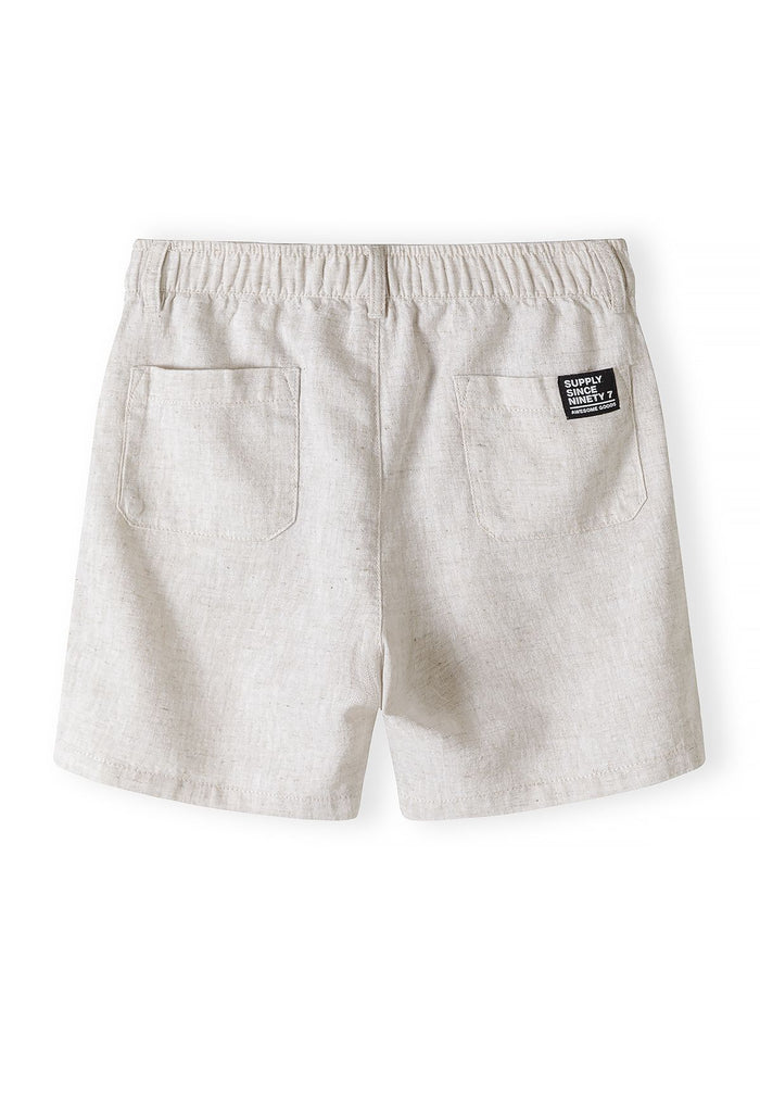 Beige linen cotton shorts with elasticated waistband and back pockets, back view.