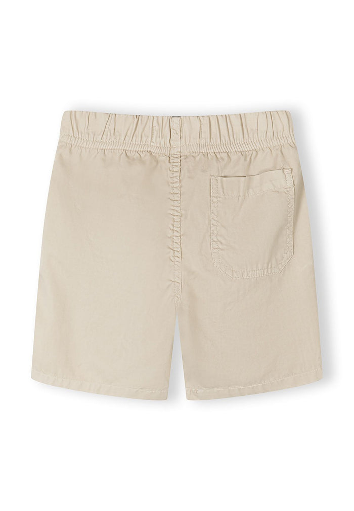 Back view of beige boys' woven shorts with elasticated waistband and back pocket.