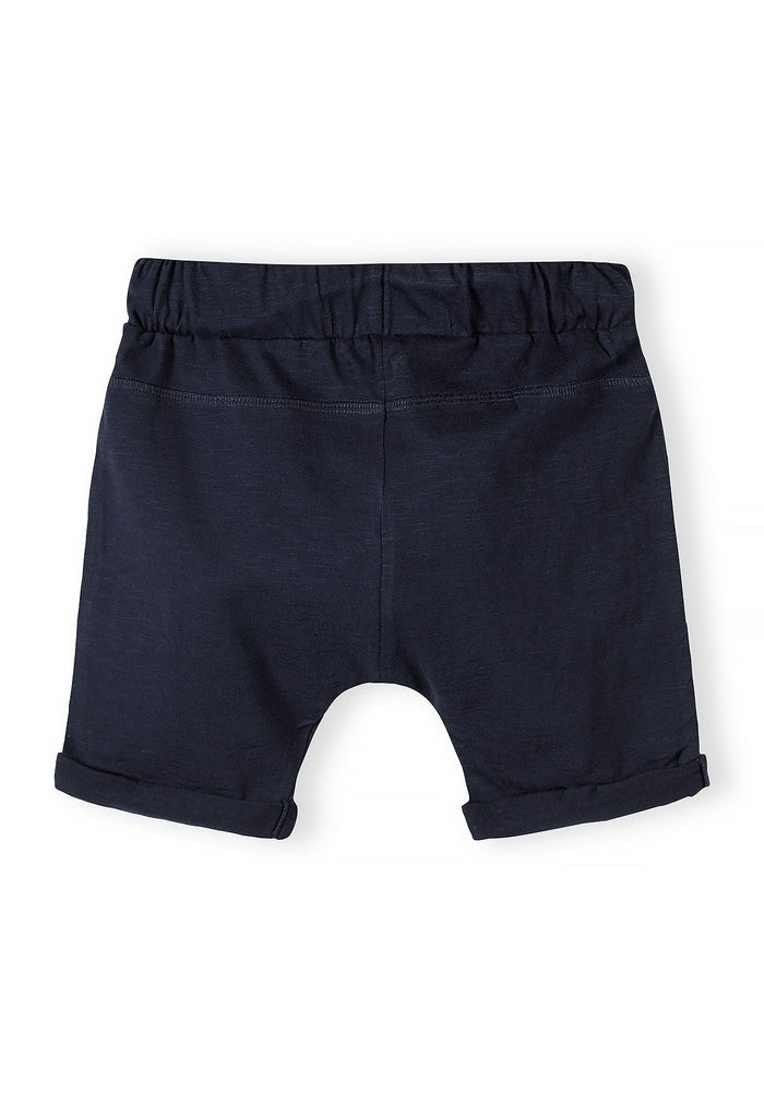 Boys cotton jersey shorts, back view, navy with rolled hems and elastic waistband.