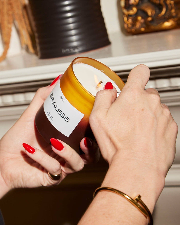Person holding a candle labeled 'GIRLS' with a decorative background