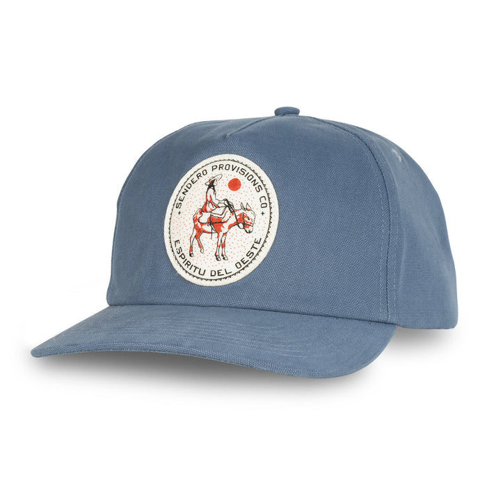 Blue baseball cap with round embroidered patch showing a rider on a horse and desert scene