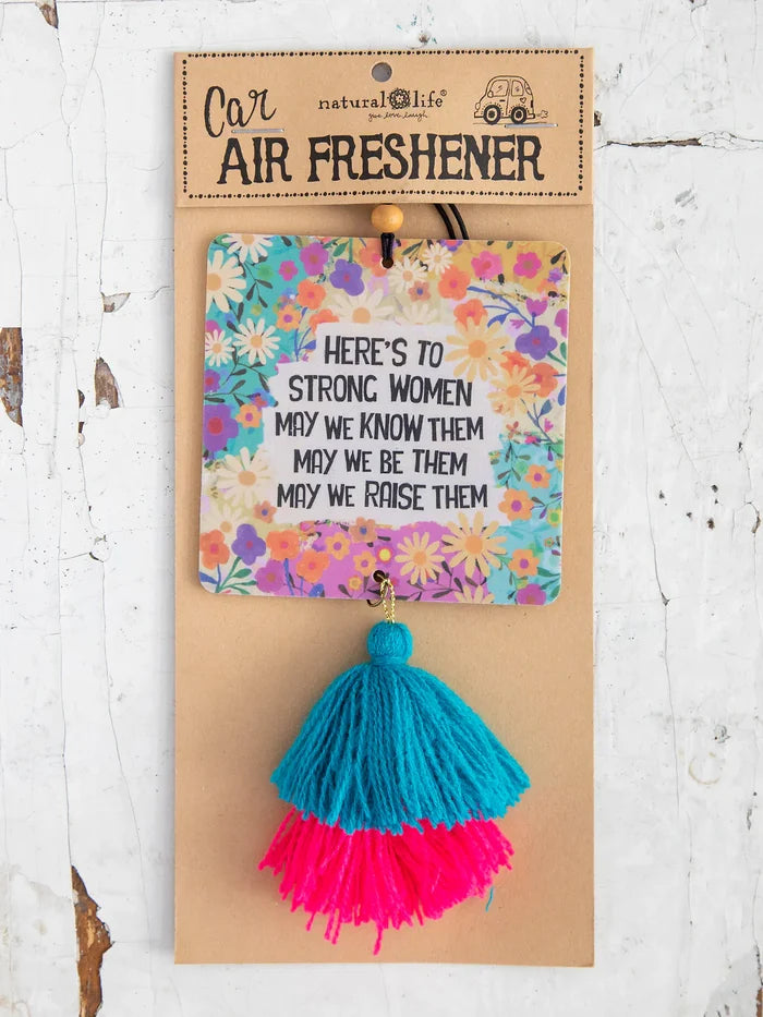 Carded car air freshener featuring the same floral print and a turquoise and pink tassel against kraft backing