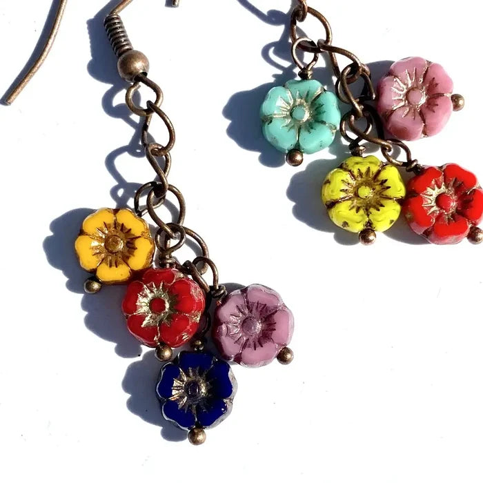 Close-up of Cascade Flower Dangle Earrings showing bright flower charms on bronze chain