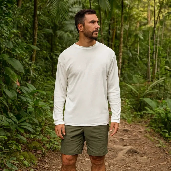 Man wearing a white Sub Zero Cool T wicking long-sleeve shirt and green trek shorts standing on a forest path.