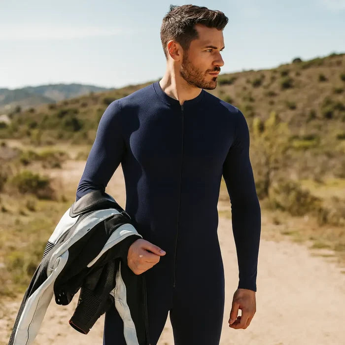 Man wearing a navy Sub Zero Cool T wicking onesie whilst holding motorbike leathers in the sun