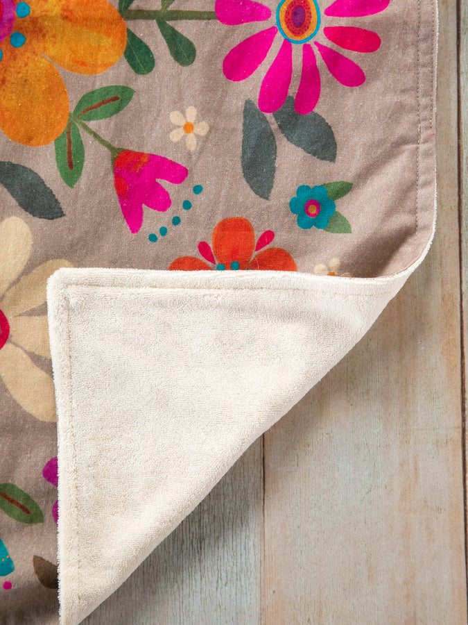 Close up of taupe dish towel showing bright multicolored flower print
