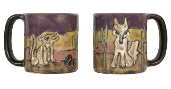 Two round stoneware mugs with desert scenes; left shows a crouching coyote beside a cactus, right shows a standing coyote among tall cacti.