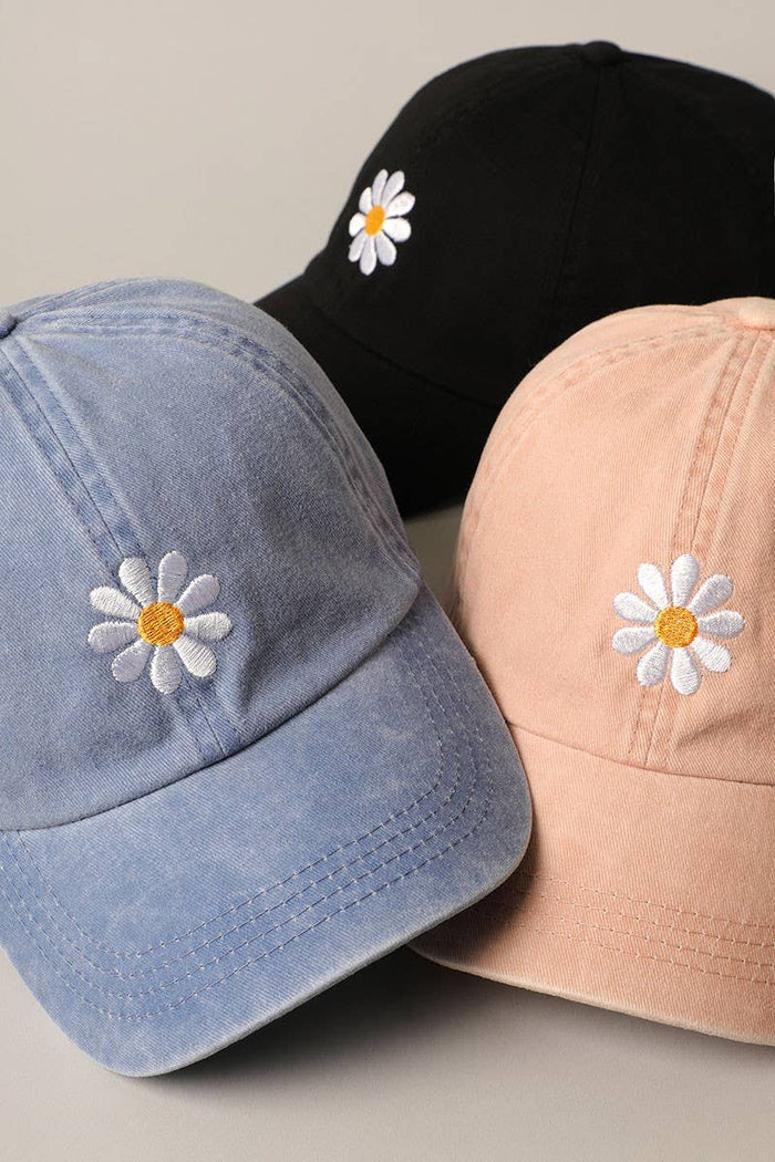 Blue, black, and pink adjustable baseball caps with white daisy embroidery