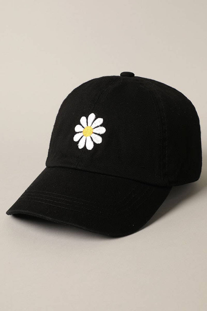 Close up of white daisy embroidery with orange center on a black cap