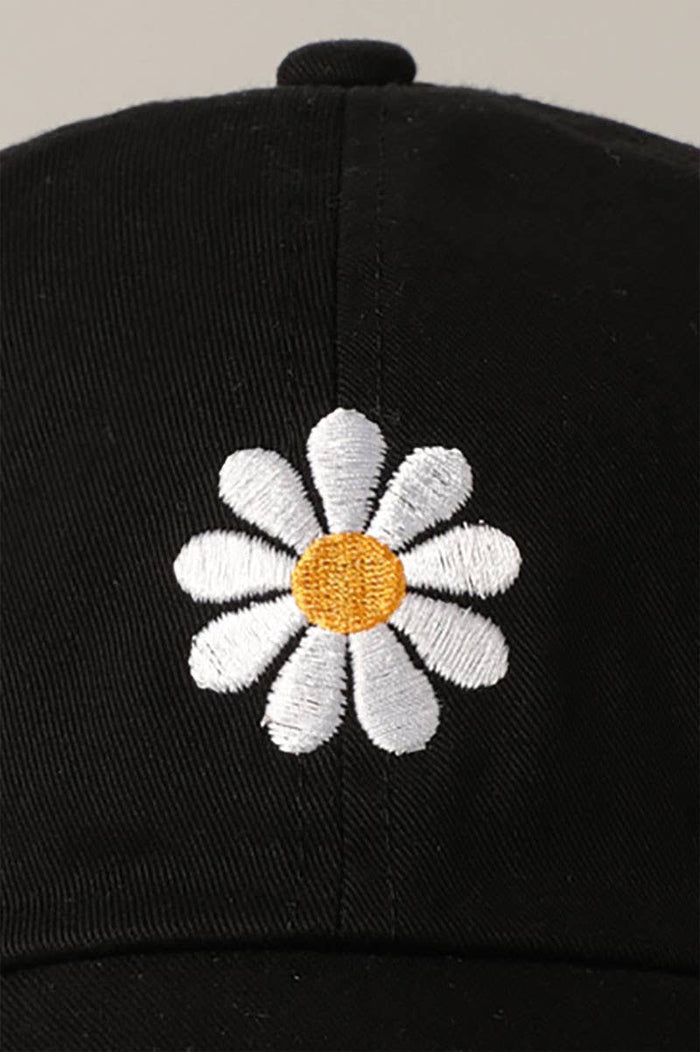 Black adjustable baseball cap with white embroidered daisy and yellow center on the front