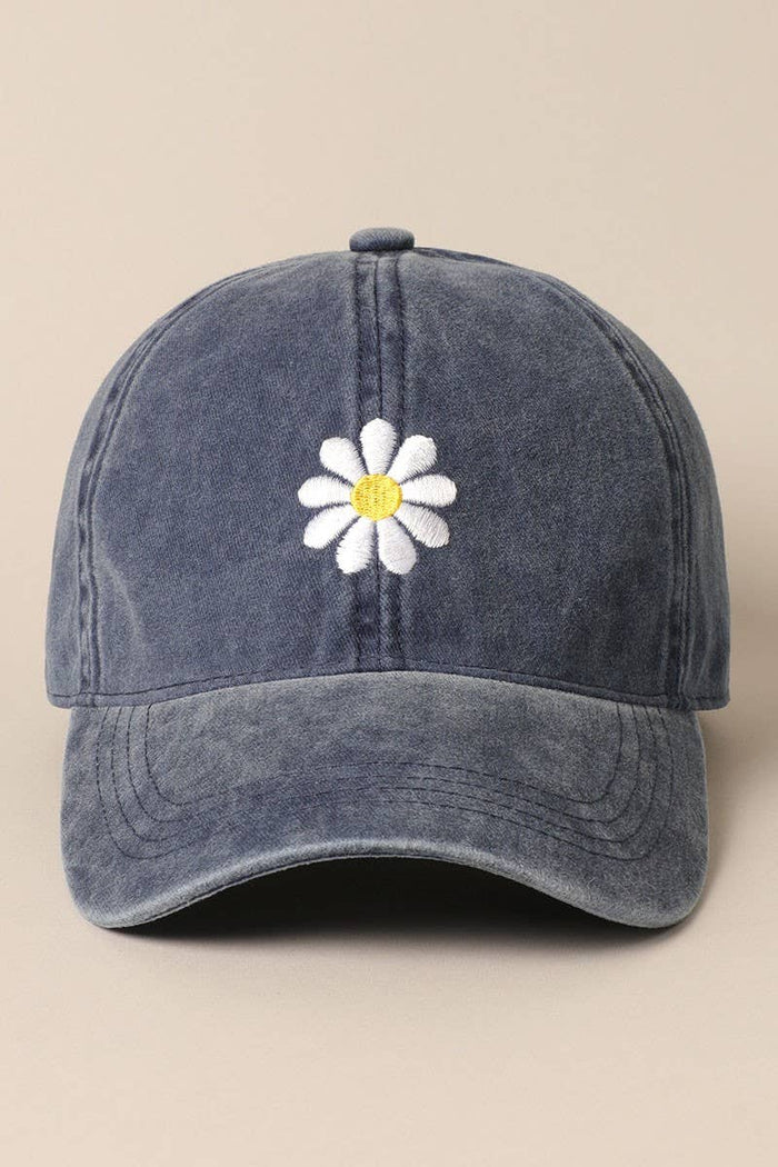 Blue denim adjustable baseball cap with a white daisy embroidery at the front.