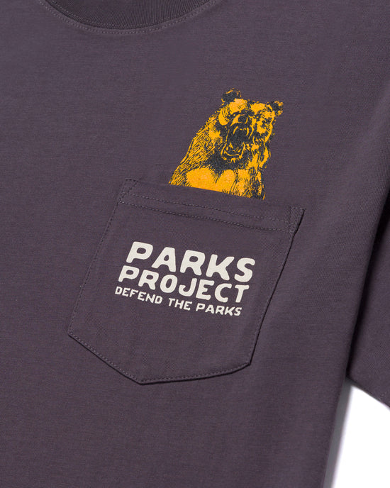 Purple Defend the Parks Bear Pocket Tee with a yellow bear peeking from the chest pocket