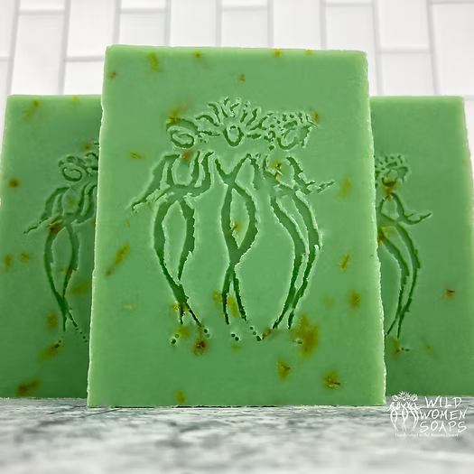 Close-up of Desert Aloe Soap with embossed emblem on a green bar and golden specks