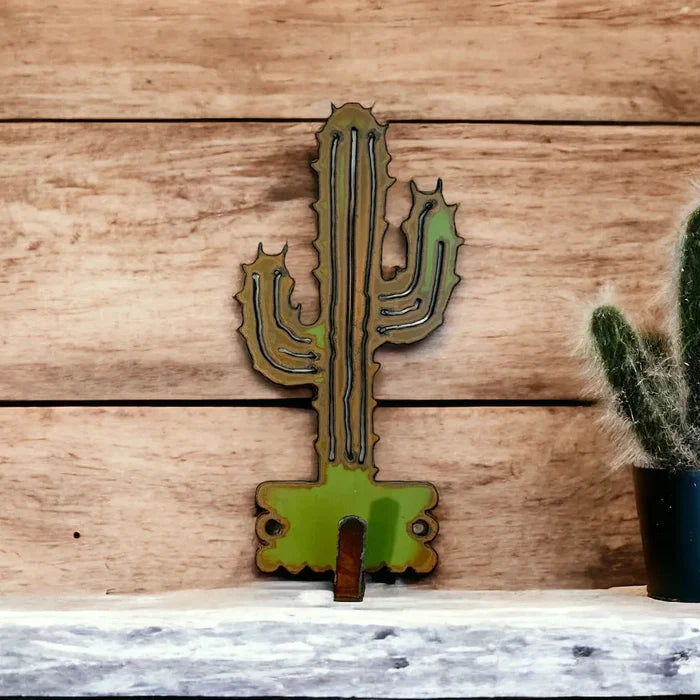 Desert cactus shaped wall hook in green metal mounted on a wood plank wall with a small bottom hook