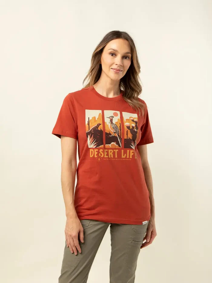 Woman wearing red Desert Life T-shirt with three panel desert scene graphic in a casual pose.