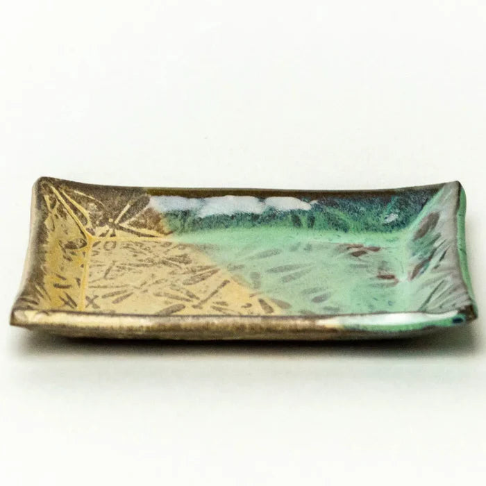 Green glazed ceramic tray with an embossed leaf pattern and curved edges.