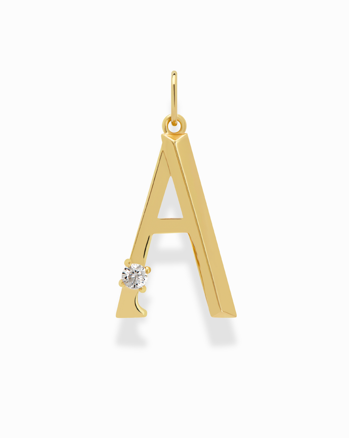 The Eloise Letter Charm by Mod + Jo is a gold-plated pendant shaped like the letter A, accented with a small round diamond at the bottom left. Designed with a top loop for attaching to chains, it's displayed against a white background.