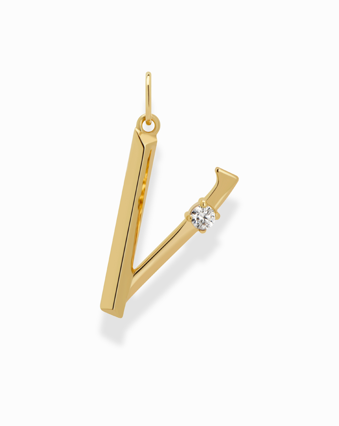 The Eloise Letter Charm by Mod + Jo is a gold plated pendant shaped like a V, adorned with a sparkling diamond on the right arm and a top loop for easy attachment to your favorite chain.