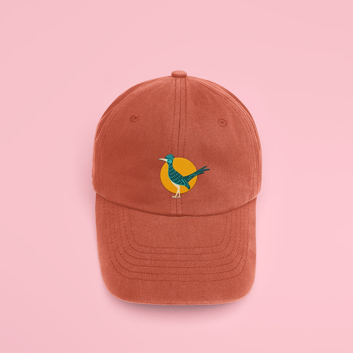 Embroidered Roadrunner on burnt orange baseball cap with a yellow circle behind the bird