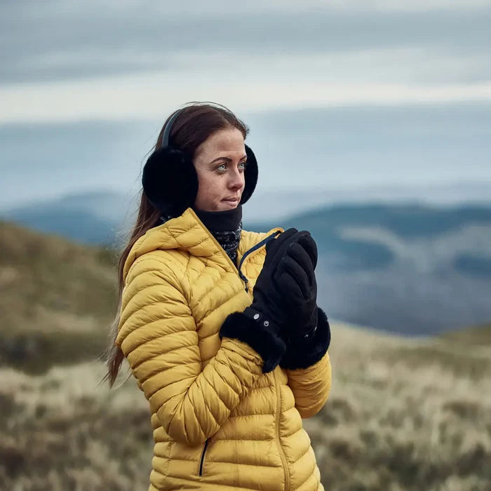 Lifestyle image of a woman wearing a pair of Extremities Chamonix waterproof gloves in the winter outdoors on a heath