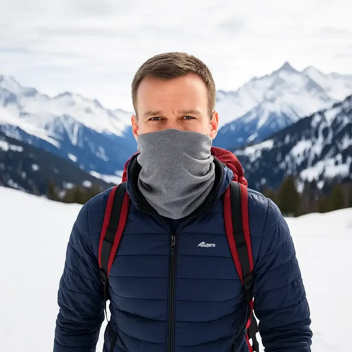 Man wearing a Sub Zero Factor 1 Eco thermal neck warmer in grey colour whilst walking in the snowy Alps