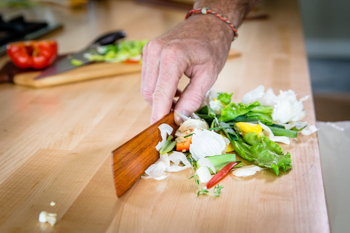 Assorted chopped vegetables on a cutting board with a wooden spatula ready to stir